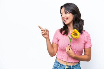 Young hispanic woman holding sunflower isolated on white background pointing finger to the side and presenting a product