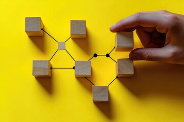 A person holds a wooden block in front of a collection of similar blocks, great for education and learning scenarios