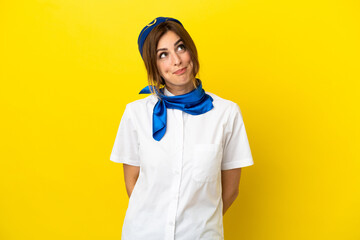 Airplane stewardess woman isolated on yellow background and looking up