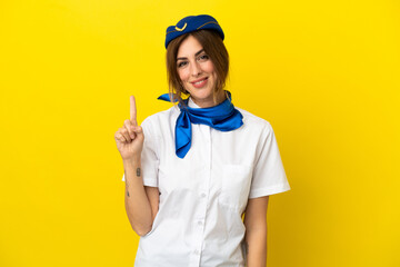 Airplane stewardess woman isolated on yellow background showing and lifting a finger in sign of the best