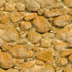 An old stone wall. Background of yellow stones. Stone texture. Seamless.