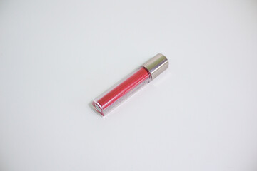 Red lip gloss in elegant glass bottle with shiny lid, container with brush isolated on white background, red lipstick