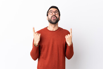 Fototapeta premium Caucasian handsome man with beard over isolated white background surprised and pointing up