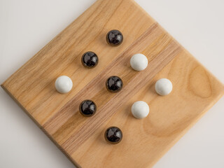 top view of black and white marbles version of tic tac toe board game