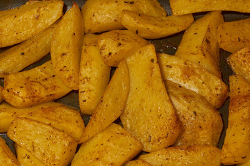 Baked potato slices with seasoning mixture. Close-up.