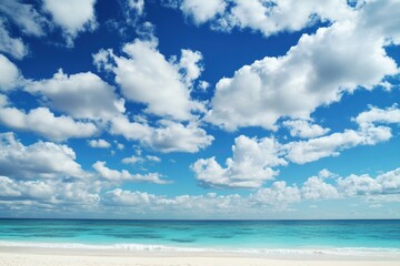 Fototapeta premium A sunny day at the beach with clear blue sky and white clouds