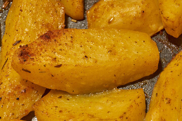 Baked potato slices with seasoning mixture. Close-up.