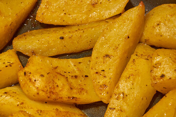 Baked potato slices with seasoning mixture. Close-up.