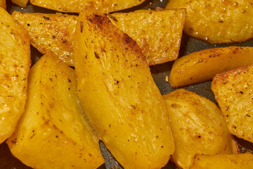 Baked potato slices with seasoning mixture. Close-up.