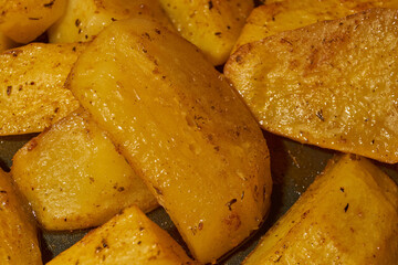 Baked potato slices with seasoning mixture. Close-up.