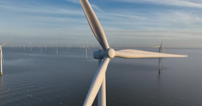 Aerial close up views of large windturbines on water, offshore wind park.