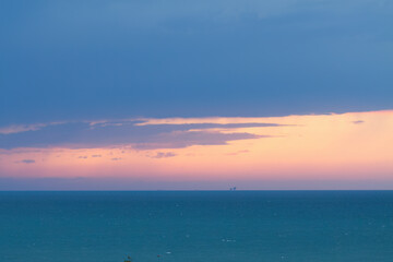 Fototapeta premium blue sea and pink sky during a storm, stormy sea, blue sea, purple sky, azure blue, high waves, splashing waves