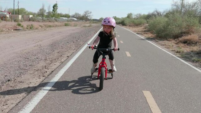 Little 4 Year old Girl Riding Bike Forward