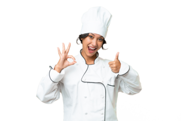 Young chef Argentinian woman over isolated background showing ok sign and thumb up gesture