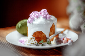 Easter cake, Easter bread, white glaze, pink flowers, white dish, white flower, olive egg, dark background