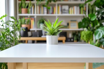 Bright white rectangular wooden table with overhead lighting and blurred office background featuring desk, bookshelves, and plants
