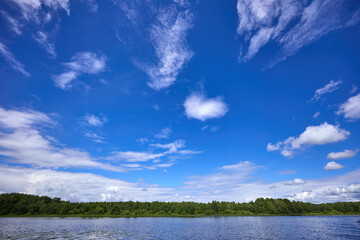Obraz premium Beautiful summer river at sunny day with clouds reflection in the water