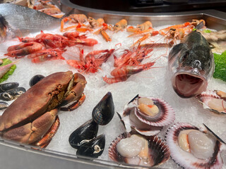 Platter Seafood. Fresh fish and sea food on ice, overhead flat lay view on a black background.
