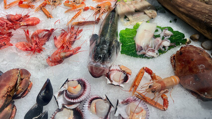 Platter Seafood. Fresh fish and sea food on ice, overhead flat lay view on a black background.