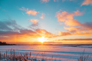 Beautiful bright sunset over a snow-covered field.