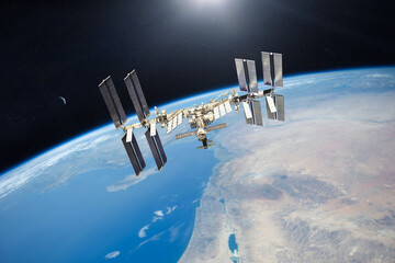 International Space Station on low-orbit of Earth with sun rays. 