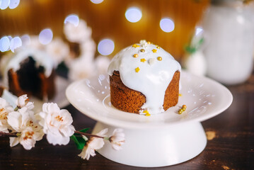 Easter cake, Easter bread, white glaze, gold stars, white dish, white flower, dark background, Bokeh