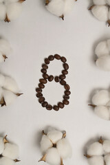 International Women's Day 8 March. Number eight made of coffee beans on white background. Cotton inflorescence plant. Greeting card