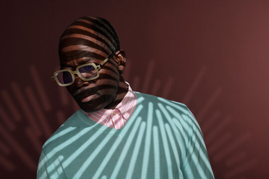 Man Wearing Sunglasses and Striped Light Shadows