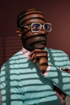 Contemplating Man in Striped Light Wearing Glasses
