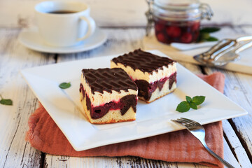 chocolate-covered cake with vanilla pudding and sour cherries