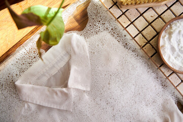 white shirt lies in water with foam, the concept of eco-friendly washing