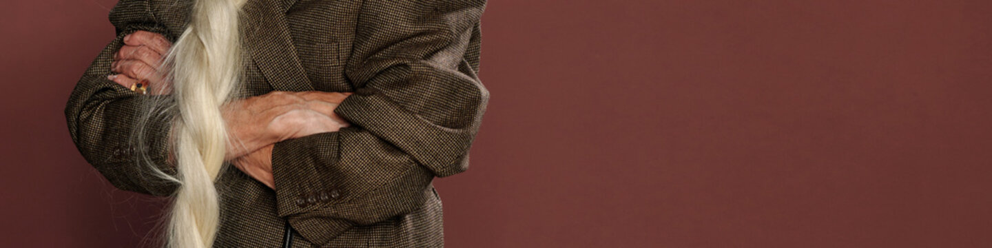 Crossing Arms Wearing Brown Blazer Against Brown Background