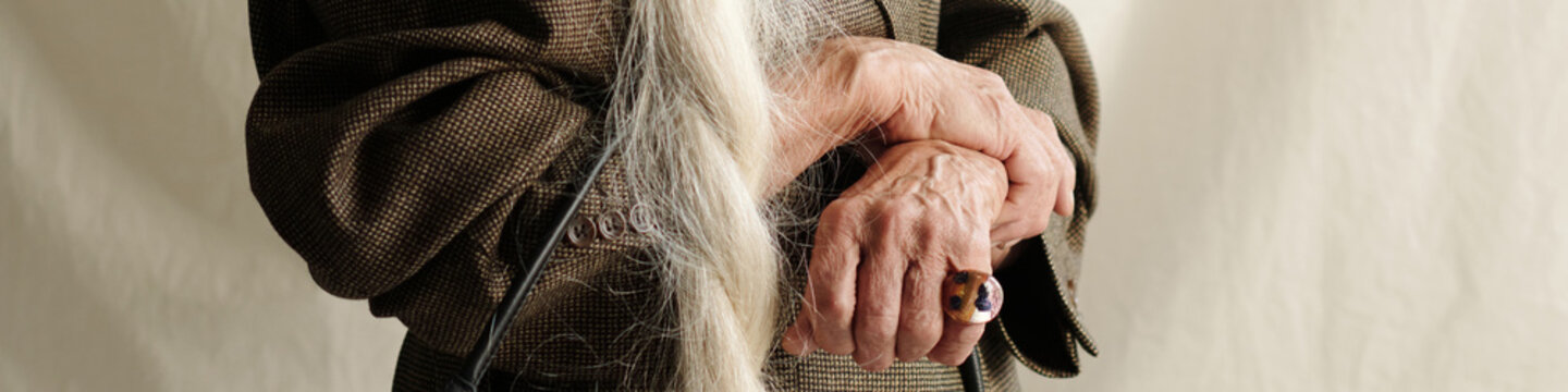 Close-Up of Elderly Hands Resting on Walking Cane