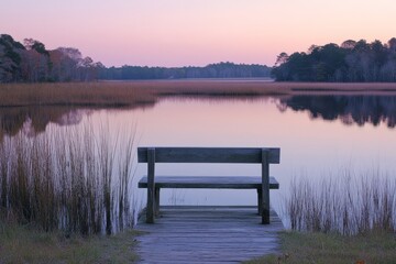Peaceful lakeside scene with a wooden bench overlooking calm water at sunset