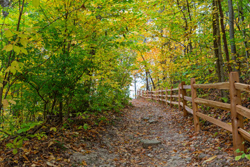 Hiking trail running along a log fence in a wooded area of Klondike County Park in Augusta,...