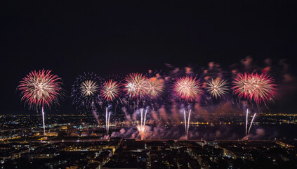 Bright Fireworks Display Lighting Up the Night Sky Over a Cityscape