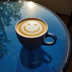 Happy Latte Art in Coffee Cup on Sunny Outdoor Table