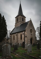 Fototapeta premium Stone Church in Cemetery Grey Sky Gothic Architecture Gravestones Religious Building