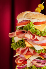 Giant dagwood sandwich overflowing with ham, cheese, and vegetables