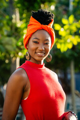 Garifuna woman wearing traditional orange turban smiling in nature