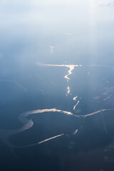 A silhouette of a river winding, similar to a hieroglyph, aerial photography in Thailand Phuket with the glare of the setting sun. Stunning Aerial View Of Winding Rivers That Beautifully Reflect