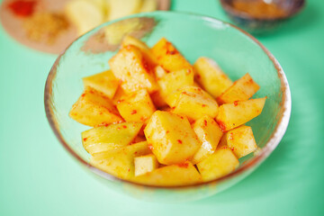 Close-up of pickled mango cubes in a bowl, mango pickle, shot from above