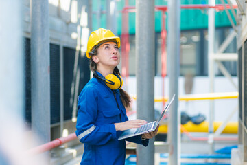 Close up hand industrial industrial plant with a tablet in hand, Engineer looking of working at industrial machinery setup in factory.	
