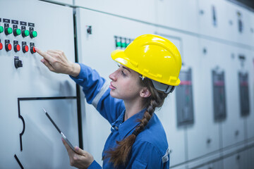 industrial engineer wearing a white helmet while standing in a heavy industrial factory behind. The Maintenance looking of working at industrial machinery and check security system setup in fact	
