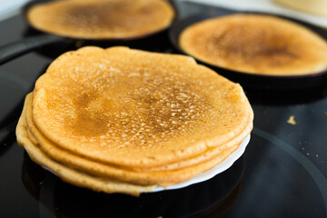 stack of appetizing flour pancakes in the kitchen during cooking