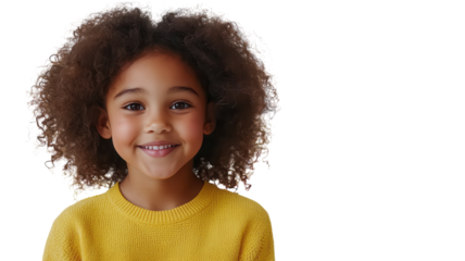 Happy child with curly hair wearing yellow sweater smiles warmly at the camera in a bright, cheerful setting with soft lighting