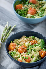 Avocado pesto pasta with peas, asparagus and roasted tomatoes