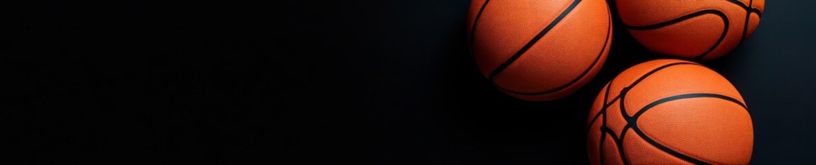 Three basketballs on a dark background create a dramatic sports image perfect for basketball game, training, or championship themes.