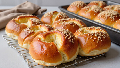 Freshly baked sesame rolls on a cooling rack