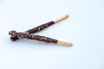 chocolate-covered bread stick with nuts, isolated on white. Bright lighting highlights the details. Simple snack image